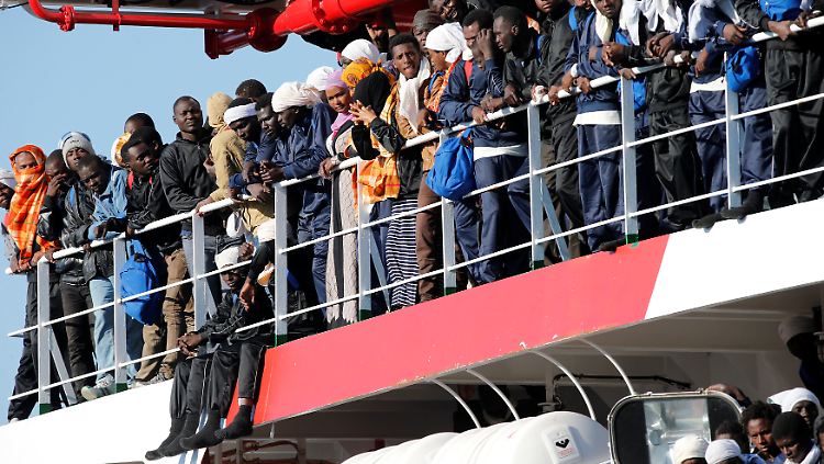 Gerettete Flüchtlinge an Bord eines Schiffes, das in den Hafen von Neapel einläuft.