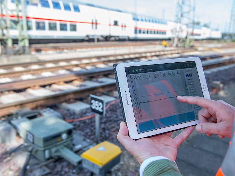 Ein Techniker kontrolliert mit Hilfe eines Weichenumlaufdiagramms auf seinem Tablet eine Weiche.