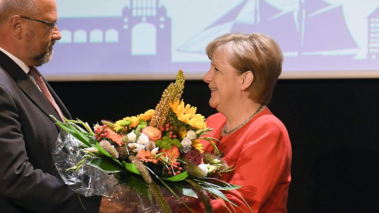 Am Montag erhielt Merkel auf dem Sommerempfang der IHK Rostock einen Blumenstrauß zu ihrem 63. Geburtstag.