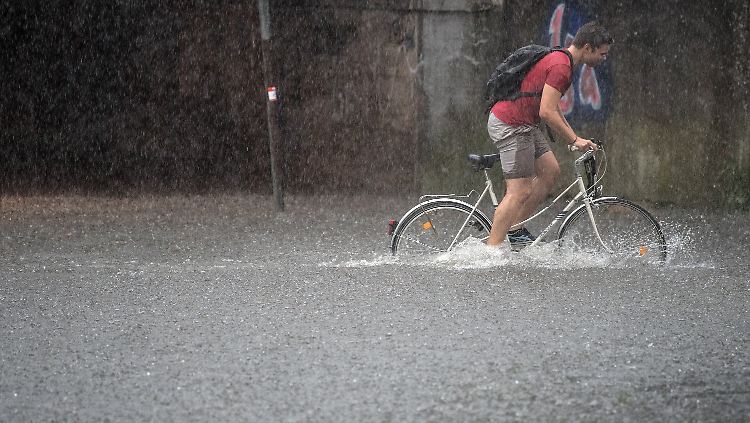 Ein Radfahrer in Köln kämpft sich durch die Fluten.