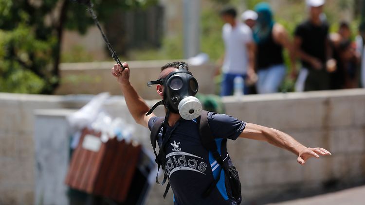 Ein Palästinenser schießt mit einer Steinschleuder auf israelische Soldaten. 