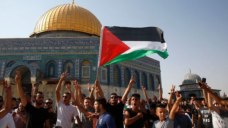 Palästinenser schwenken eine Fahne vor der Felsenmoschee in Jerusalem.