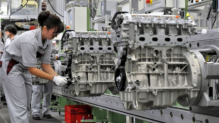 Beim Automobilzulieferer MDC Power im thüringischen Kölleda montiert eine Mitarbeiterin einen Vierzylinder-Benzinmotor. 