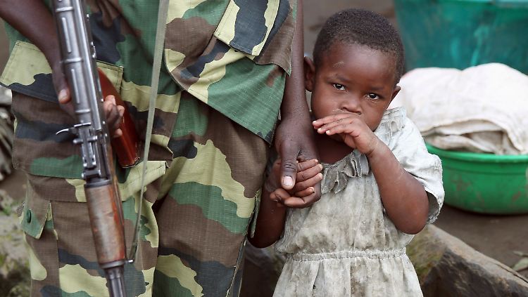 Ein Mädchen hält die Hand eines Rebellenkämpfers: Viele Kinder im Kongo geraten in die Hände von Milizen.