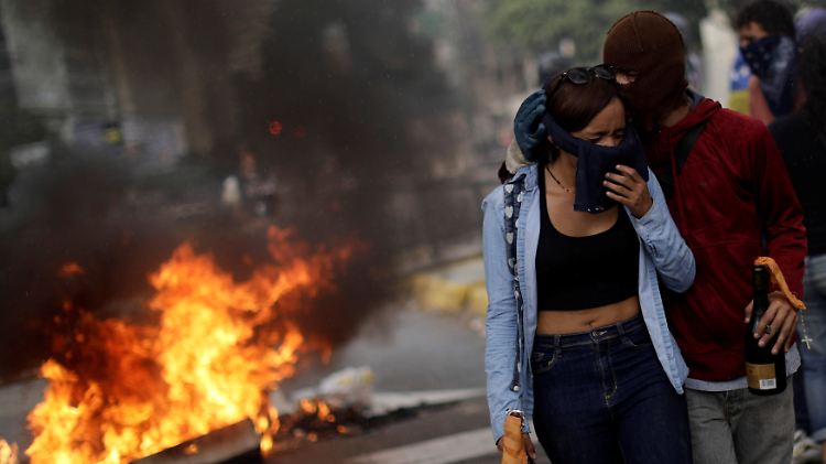 Oppositionelle Demonstranten neben einer Barrikade in Caracas.