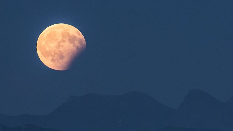 Blick auf die partielle Mondfinsternis über den Berner Alpen. Bei einer partiellen Mondfinsternis stehen Sonne, Erde und Mond in etwa in einer Reihe. 