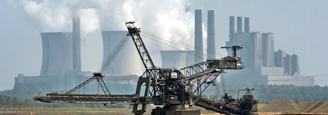 Braunkohle-Bagger fährt vor dem RWE-Kraftwerk Niederaußem.