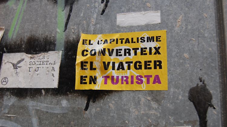 Aufkleber mit der Aufschrift "El Kapitalisme converteix el Viatger en Turista" ("Der Kapitalismus verwandelt den Reisenden in einen Touristen") in Palma de Mallorca.