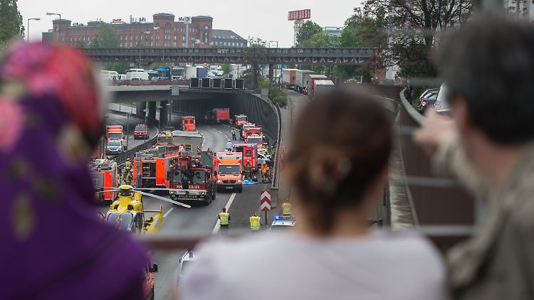 Gaffer blicken von einer Brücke aus auf einen Unfall.