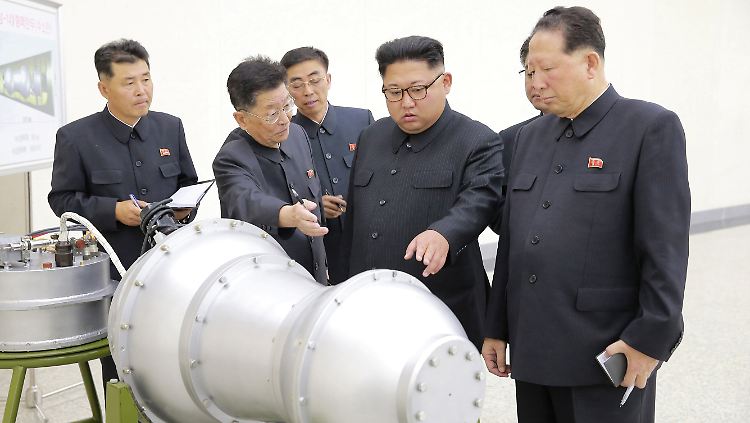 Kürzlich veröffentlichte Bilder des nordkoreanischen Regimes sollen Diktator Kim (M.) mit einer Wasserstoffbombe zeigen.