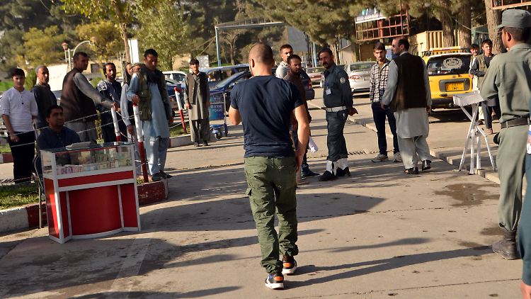 Die abgeschobenen Afghanen verlassen nach ihrer Ankunft den Flughafen Kabul.