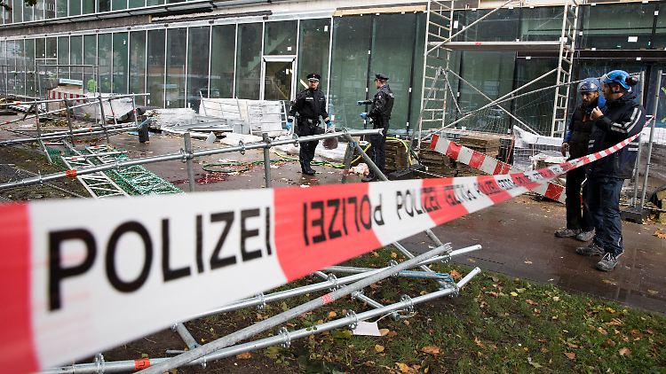 Lebensgefahr durch herabfallende Gerüstteile: In der Hamburger Innenstadt sichern Polizeibeamte die Unglücksstelle.