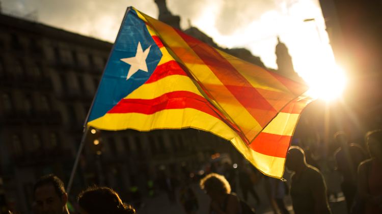 Demonstranten zeigen in Barcelona die Flagge Kataloniens.