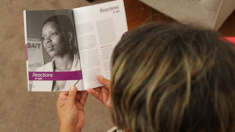 Barbara Williams, die Leiterin des psychologischen Beratungsdienstes der Hilfsorganisation Rape Crisis in Kapstadt (Südafrika), blättert in einer Broschüre für Vergewaltigungsopfer.