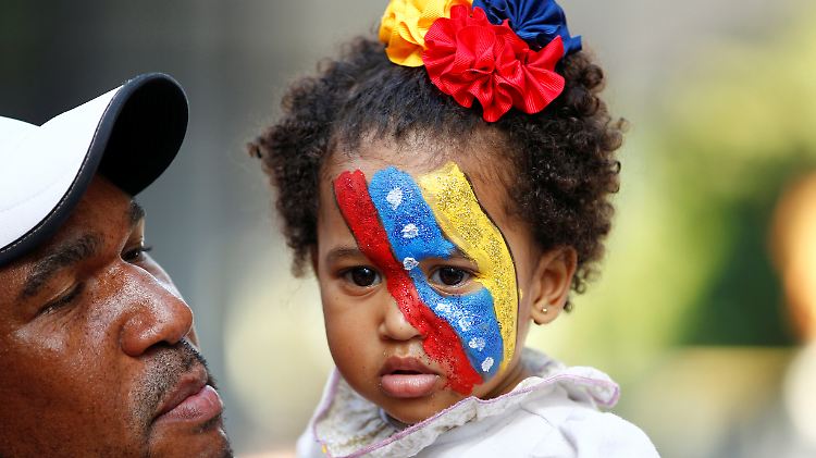 Ein Kind und sein Vater vor der Volksabstimmung gegen Präsident Nicolás Maduro - der lässt seine Gegner verfolgen.