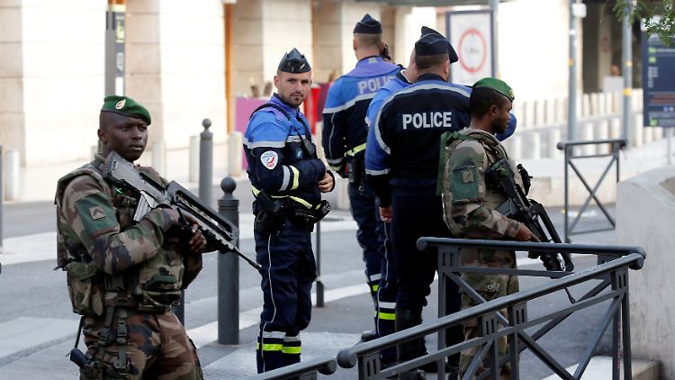 Schwer bewaffnete Einsatzkräfte riegeln den Tatort in Marseille ab.
