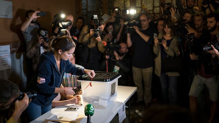 Unter den Augen zahlreicher Medienvertreter öffnet eine Wahlhelferin in Barcelona eine Wahlurne, um mit der Stimmauszählung zu beginnen.