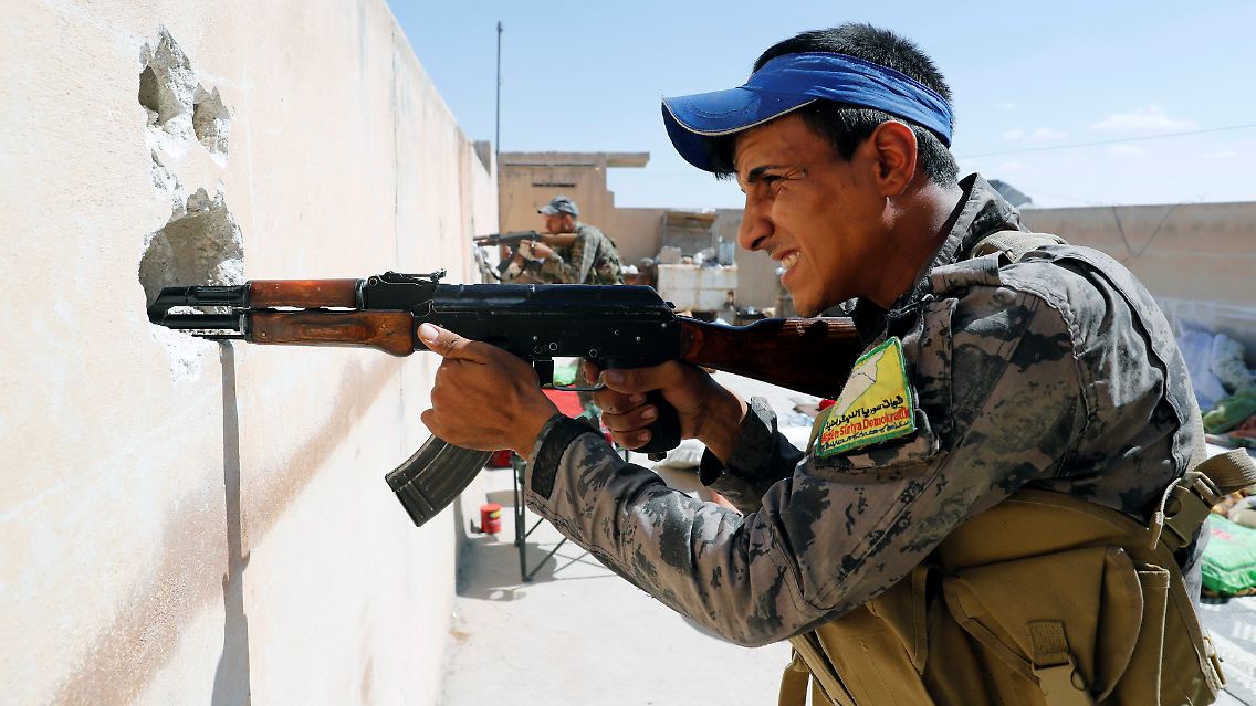 Ein Kämpfer der SDF-Truppen schießt von einem Hausdach in Rakka.