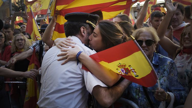 Eine Frau umarmt in Barcelona einen Polizisten der Guardia Civil.