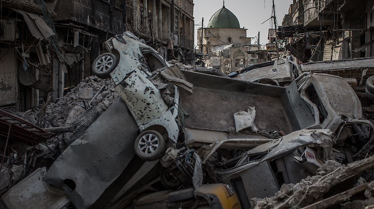 Auf dem Weg zur Großen Moschee liegen Autos und Kleinlaster in einem Krater übereinander gestapelt.