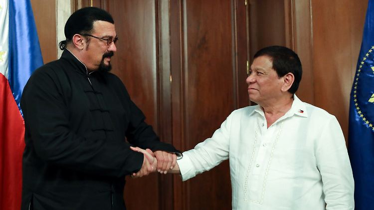 Wäre es ein Film, würde der Held (l.) beim Schurken (r.) eben noch den Puls fühlen - und ihn dann gekonnt überwältigen. So ist es nur ein freundschaftlicher Handshale zwischen Seagal (l.) und Duterte - beide karateerprobt.