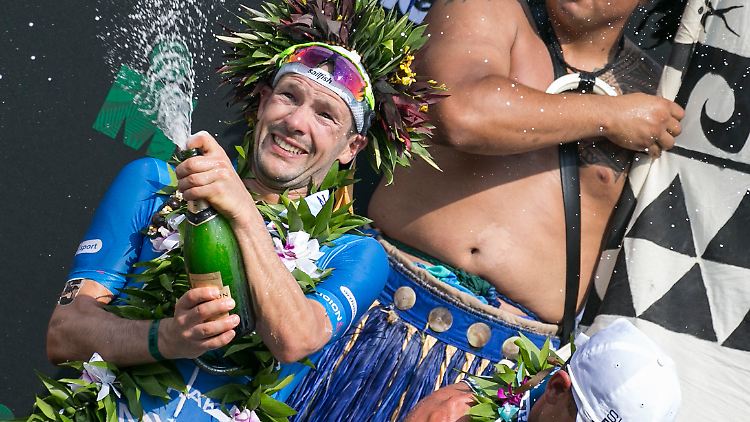 Patrick Lange kann es kaum glauben: Er gewinnt den Ironman auf Hawaii. Die Sektdusche hat er sich verdient.