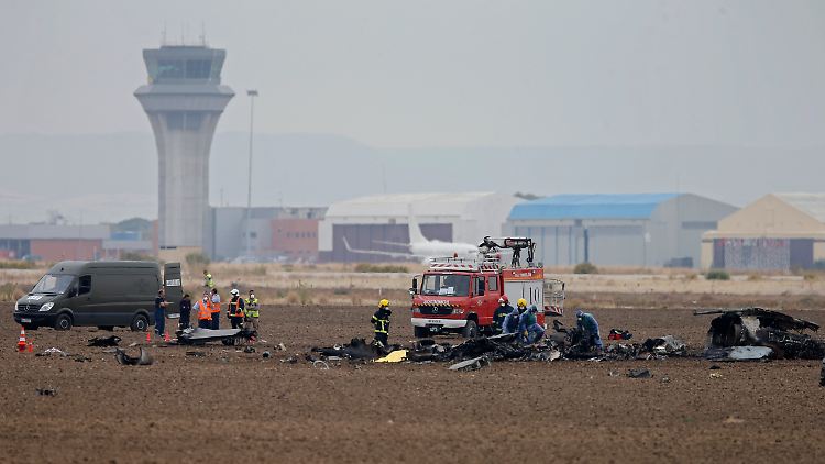 Trümmerteile liegen verstreut neben der Startbahn: Feuerwehrleute sichern die Überreste der abgestürzten F-18.