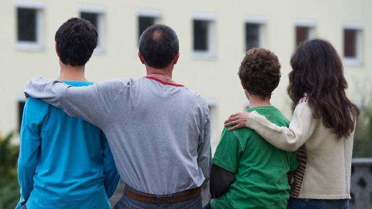 Eine syrische Familie sitzt vor ihrer Flüchtlingsunterkunft im brandenburgischen Eisenhüttenstadt.