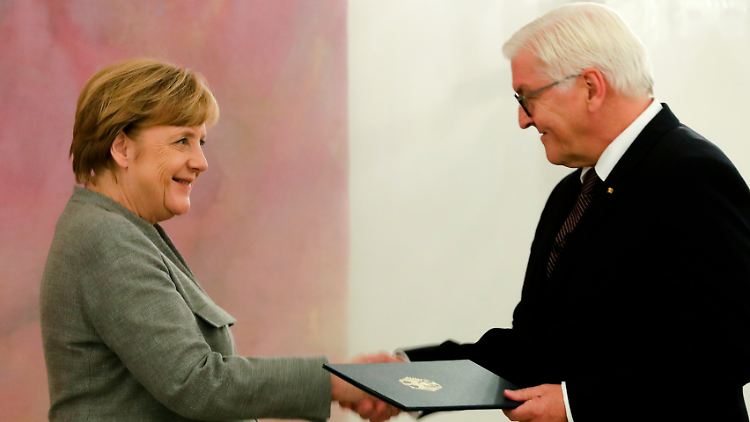 Bundespräsident Steinmeier übergibt Kanzlerin Merkel ihre Entlassungsurkunde.