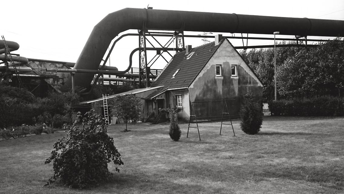 Oberhausener Idylle: der emsig gepflegte Rasen, das Eigenheim mit Kohlenstaubfassade und das Knäuel von Rohren im Hintergrund. Vielerorts wurden die gigantischen Leitungen inzwischen abgebaut. In Teilen von Oberhausen und Dortmund gehören sie immer noch zum Alltagsbild.