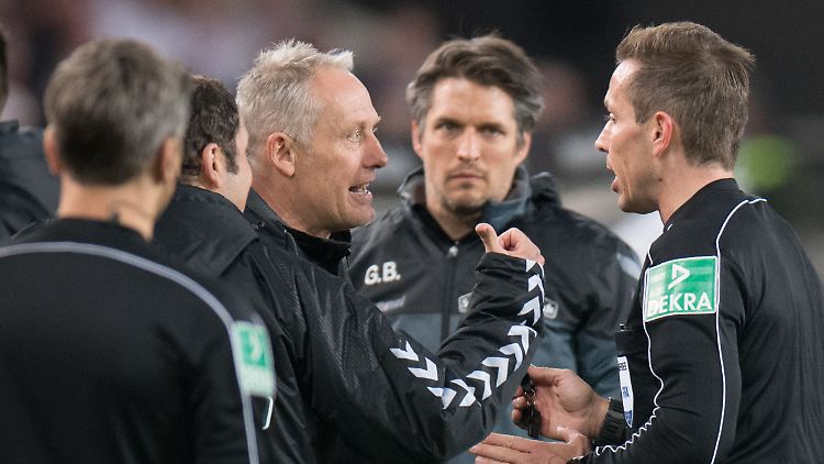 Freiburgs Trainer Christian Streich (l.) diskutiert mit Schiedsrichter Tobias Stieler (r.) - ohne Erfolg.