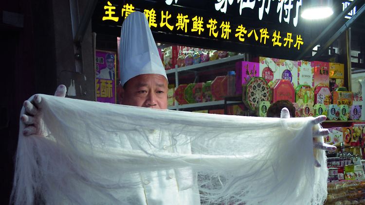 In den Garküchen Chinas kann man meist den Köchen bei der Arbeit zusehen: beim Nudeln ziehen, Gemüse schnippeln oder beim Rühren im Wok.