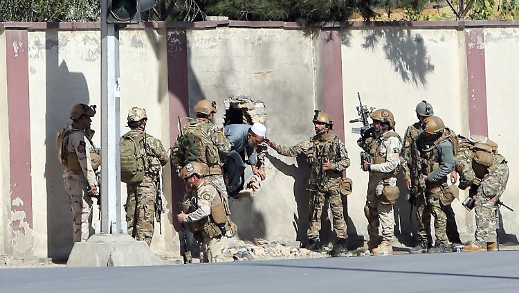 Einsatzkräfte bringen Mitarbeiter des Senders aus dem Gebäude.