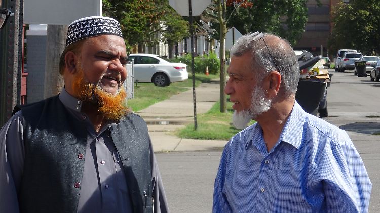 Bevor er auf die Suche nach Hilfsbedürftigen geht, spricht Khalid Iqbal (r.) mit dem Chef der gegenüber liegenden Koranschule.