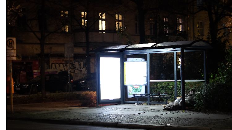Eine Frau hat sich für die Nacht im Friedrichshain in einer Bushaltestelle eingerichtet.