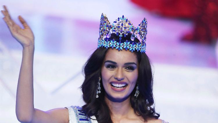 Strahlendes Lächeln, Arm zum Winken erhoben, Hand leicht abgeknickt - so präsentiert sich eine Miss World.