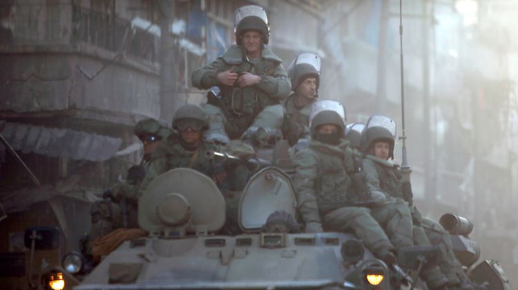 Russische Soldaten patrouillieren durch eine Straße im syrischen Aleppo.