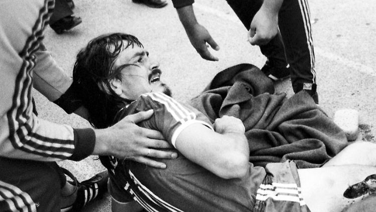 Ewald Lienen schreit vor Schmerzen. Sein Oberschenkel ist offen.