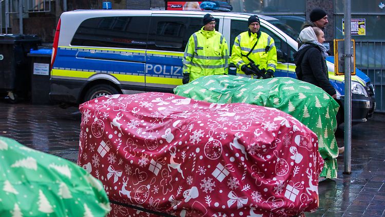 Auf einem Weihnachtsmarkt in Lübeck (Schleswig-Holstein) sind die Sandsackbarrieren als Geschenke verpackt.