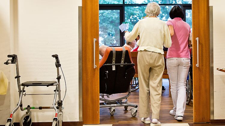 Eine auf Demenzkranke spezialisierte Pflegerin begleitet eine ältere Frau.