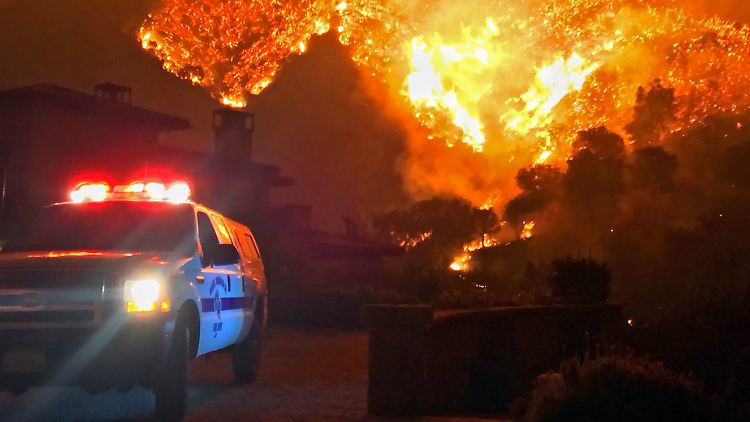 Eine Polizeistreife riegelt bei Santa Barbara die Sraße zu einem Feuer ab.