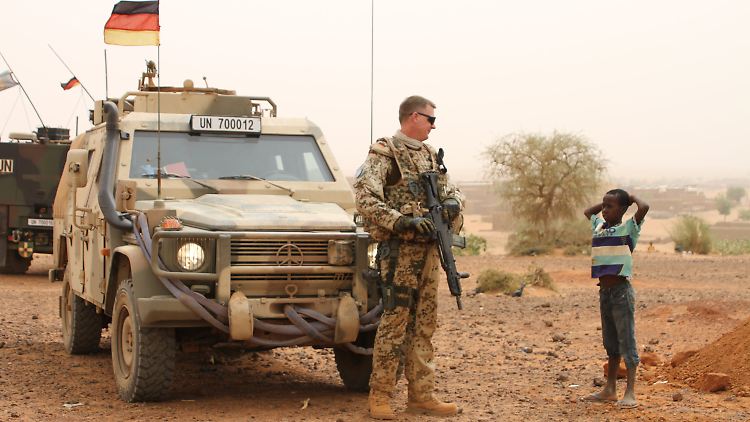 Ein Bundeswehrsoldat unterhält sich in Mali mit einem Kind.