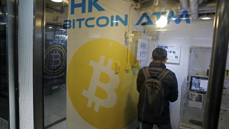 Ein Mann in Hongkong benutzt einen Automaten, an dem Bitcoins ge- und verkauft werden können.