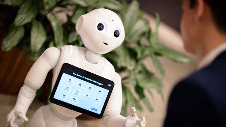 Der Roboter "Pepper" spricht mit einem Besucher des Kaufhauses "Gerber" in Stuttgart.
