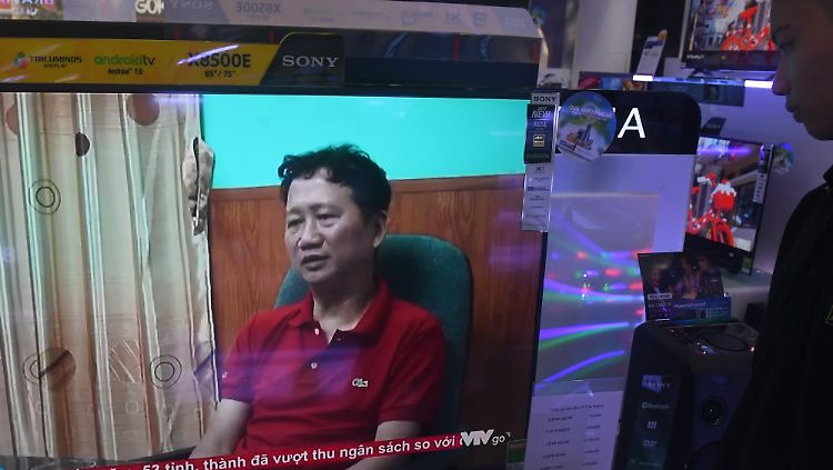 Ein Verkäufer eines Fernsehgeschäfts in Hanoi schaut sich im vietnamesischen Staatsfernsehen das vermeintliche Geständnis von Trinh Xuan Thanh an.