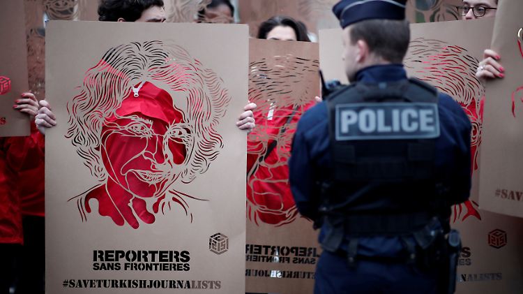 Mitglieder von Reporter ohne Grenzen zeigen vor der türkischen Botschaft in Paris Portraits inhaftierter türkischer Journalisten.