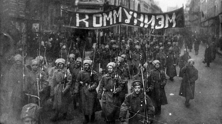 Moskau, Oktober 1917: Bewaffnete Soldaten tragen bei einer Demonstration zum Kreml ein Banner mit der Aufschrift "Kommunismus".