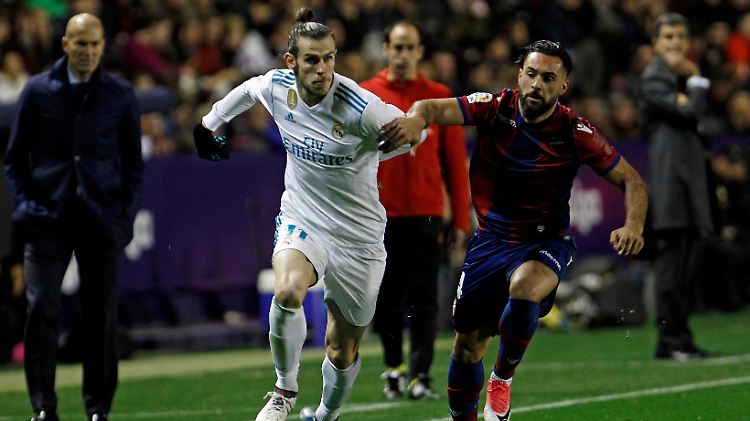 Harter Zweikampf in "La Liga": Unter den Augen von Zinédine Zidane ringt Real Madrids Gareth Bale (l.) mit Ivan Lopez Alvarez um den Ball.