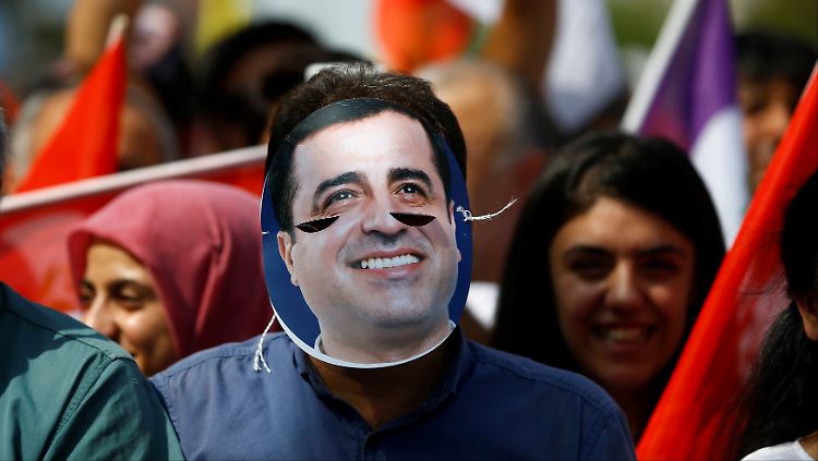 Ein HDP-Anhänger trägt eine Maske mit dem Konterfei des inhaftierten Demirtas.