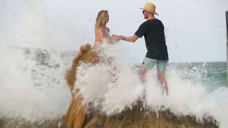 Kate Upton wird von einer Welle überrascht. Auch ihr Assistent kann ihr da nicht mehr helfen.